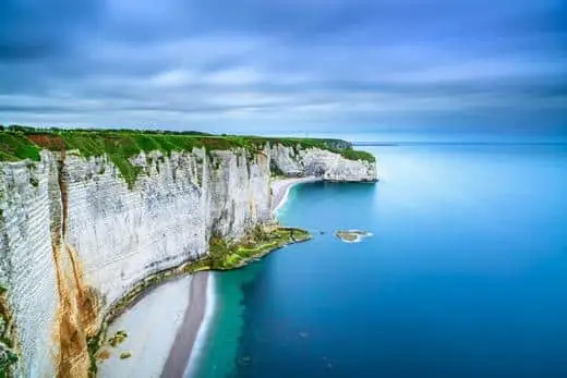 A birds-eye view of the white cliffs of Etretat and the beach below in Normandy, France.
