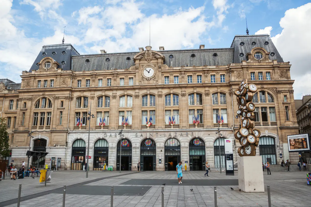 The front exterior of Gare St. Lazare rail station in Paris on a summer day.