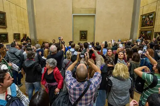 Tourists crowd the "Mona Lisa room" at the Louvre museum.