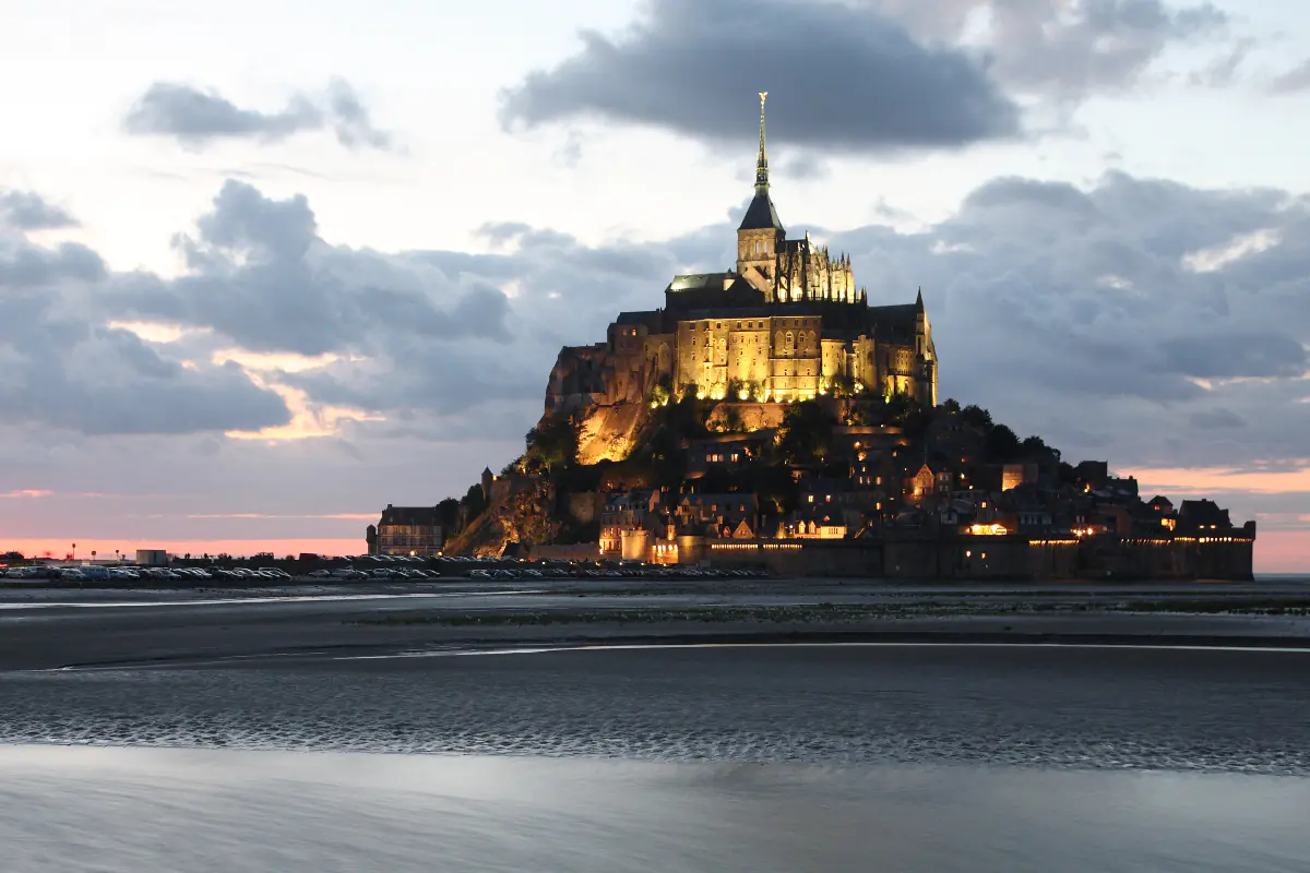 The glow of historic Mont Saint Michel from the tidal flats below.