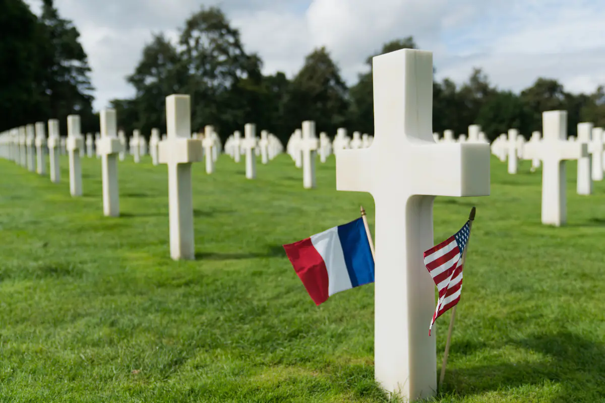 An American and French flag mark the gravestone of an American soldier at the U.S. cemetery at Colleville-Sur-Mer in Normandy, France