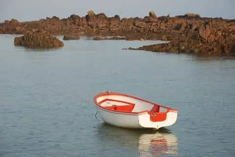 A row boat anchored along the Pink Granite Coast in Brittany, France.