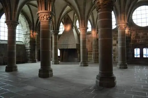 A row of columns and ancient fireplace inside of Mont Saint Michel abbey.