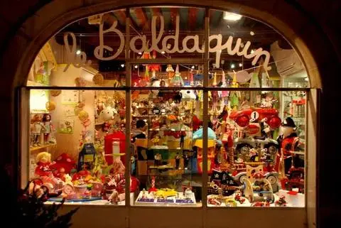 A view through the window of a small toy shop in Paris, France.