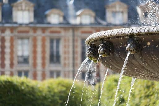 A fountain in the center of the Place des Vosges, Paris.