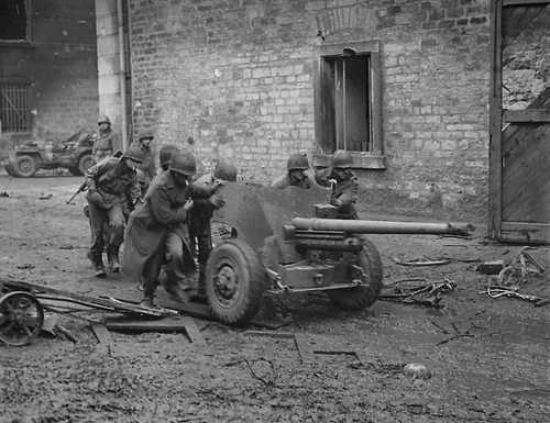 Soldiers moving artillery in Normandy after D-Day.