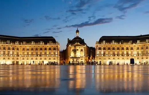 The illuminated Place de la Bourse in Bordeaux in the early evening.