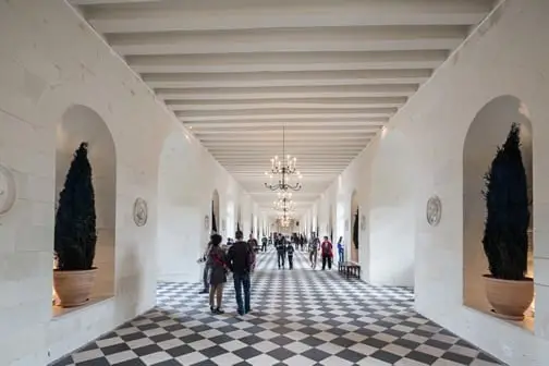 Tourists exploring an interior of Chenonceau Castle.
